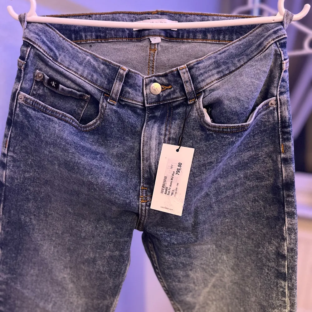 Säljer ett par snygga blå jeans från Calvin Klein i nytt skick. De har en klassisk femficksdesign och en knappgylf. Perfekta för både vardag och fest! 🕺 Nypris 800kr. Farkut & Housut.