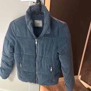 Blå manchesterjacka från Jacqueline de Yong - Säljer en snygg blå manchesterjacka från Jacqueline de Yong. Jackan har en quiltad design med dragkedja framtill och två praktiska fickor med dragkedjor. Perfekt för höst och vår när du vill hålla stilen. Den är i mycket bra skick använd bara en gång,  och redo för nya äventyr!