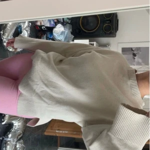 Beige stickad tröja - Säljer en supermysig beige/crémefärgad stickad tröja. Den har en normal passform med långa ärmar och ribbade muddar vid ärmslut och nederkant. Perfekt för höst och vinter när man vill hålla sig varm och stilren. Passar till allt! Kan finnas små defekter (bild 5) men inget större man lägger märke till. Passar både S/M.