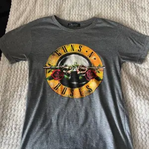 Säljer en grå t-shirt med ett Guns N' Roses-tryck på framsidan. Tröjan har inga defekter. Kontakta mig om du har fler frågor 😊