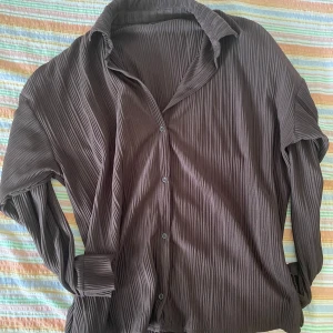 Brun skjorta från Gina  - Säljer en brun skjorta från Gina Tricot storlek M. Skjortan har ett randigt mönster och är långärmad med knappar framtill. Perfekt för höst och vinter, och den har en avslappnad och bekväm passform.