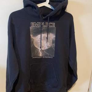 Säljer en svart hoodie med ett coolt tryck på framsidan. Den har en stor ficka fram och en skön huva med dragsko. Perfekt för en avslappnad stil eller när du vill hålla det bekvämt. Passar bra till jeans eller joggers!