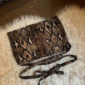 Ormmönstrad topp - Säljer en supercool ormmönstrad off shoulder-topp. med snörning som kan knytas på många sätt. Passar både till vardags och fest!