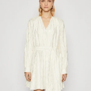 Samsøe Samsøe klänning, nypris 2300 - Säljer en superfin vit klänning från Samsøe Samsøe. Nypris 2300 kr. Lappen finns kvar då jag tyvärr aldrig fick användning för den. Den har en v-ringad, lite fluffig design med långa ärmar och ett knytband i midjan för passform samt blanka detaljer i tyget.