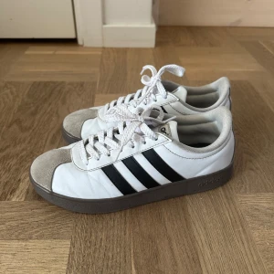 Adidas skor - Fina vita adidas VL court base sneakers, inköpta i maj, i fint skick, några skrapmärken, se bild. Kartong och originalskosnören finns.