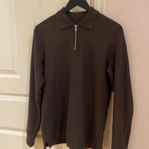 Brun tröja med dragkedja från Jack & Jones - Säljer en stilren brun tröja från Jack & Jones med dragkedja vid halsen. Tröjan har en klassisk krage, perfekt för en avslappnad look. Tröjan är i storlek S. Skicket är mycket bra, hör av vid funderingar.