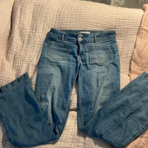 Blå jeans från Abercrombie Kids - Säljer ett par snygga blå jeans från Abercrombie Kids. Snygga lågmidjade med bootcut-stil. Har liten defekt på bakfickorna 