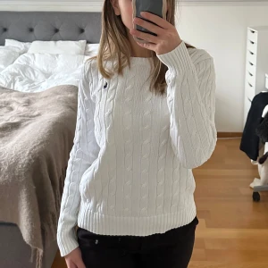 Vit stickad tröja från Ralph Lauren - Säljer en klassisk vit stickad tröja från Ralph Lauren med kabelstickat mönster. Använd men är i mycket gott skick. Storlek M. Nypris 2000kr. 