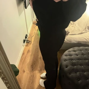 Svarta kostymbyxor från Gina Tricot - Snygga svarta byxor från Gina Tricot med låg midja och knappar framtill samt fickor med knappar baktil💕Storlek Large men passar på mig som vanligtvis har storlek Small, pågrund av låg midja fick jag gå upp i storlek!❣️Jag som är 175cm lång är byxan perfekt i längd! Pris kan diskuteras! 