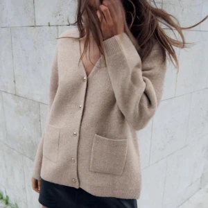 Beige kofta med knappar - (Intressekoll)Säljer en mysig beige kofta med knappar framtill och två praktiska fickor. Perfekt för kyligare dagar och enkel att matcha med olika outfits. Koftan har långa ärmar och en klassisk design.