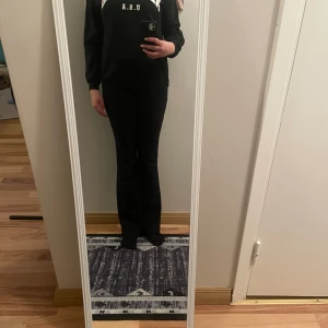 Svart sweatshirt med text - Säljer en svart sweatshirt med texten 'NEW YORK U.S.A' i vitt på bröstet. Tröjan har långa ärmar och en klassisk rund halsringning. Perfekt för en avslappnad stil.