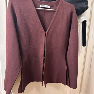 Vin röd tröja från Zara - Säljer en stilren vin röd tröja från Zara med knäppar framtill. Tröjan har en v-ringad design och långa ärmar, perfekt för kyligare dagar. Passar bra till både jeans och kjol. Pris kan diskuteras💕