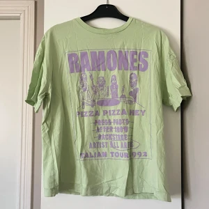 Grön Ramones t-shirt med tryck - Grön t-shirt med lila tryck från Ramones. T-shirten har ett coolt motiv. 