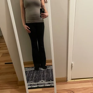 Beige topp med spetsdetaljer - Snygg beige topp med spetsdetaljer på axlarna. Toppen har en tight passform och är tillverkad i ett mjukt material. Helt ny 