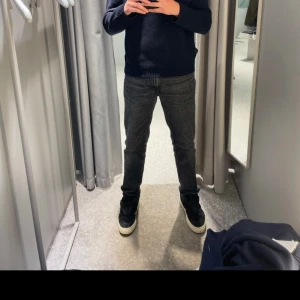 Svarta jeansbyxor - Snygga svarta jeansbyxor med en klassisk straight passform. De har en midwaist design och är perfekta för en stilren look. Byxorna har både knappar och dragkedja framtill. Storlek 32/34