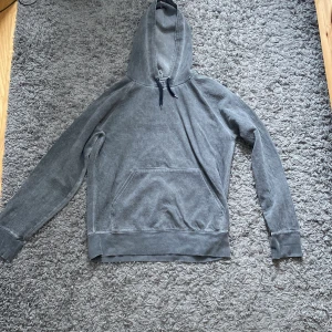 Grå washed hoodie från Our Legacy - Säljer en tvärfeta grå hoodie från Our Legacy i storlek S/Lite oversized men sitter bra på mig 181 68 kg. Bra skick utom en liten defekt vid kragen (Se bild) Nypris:3000 Mitt Pris:799