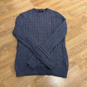 Morris tröja - Säljer en stilren blå kabelstickad tröja från Morris. Tröjan har en klassisk design med rund hals och ribbade muddar. Perfekt för kyligare dagar och ger en tidlös look.