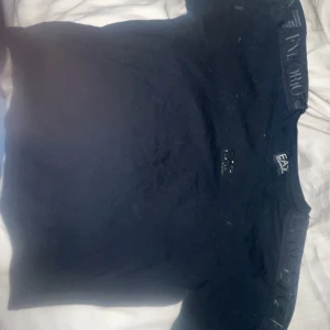 Svart t-shirt från Emporio Armani - Snygg svart t-shirt från Emporio Armani med EA7-logga på bröstet. Perfekt för en stilren look. T-shirten har en klassisk passform och är kortärmad.
