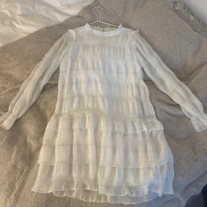 Vit långärmad klänning med volanger - Superfin vit klänning med volangdetaljer. Perfekt för vår och sommar. Hör av er om ni har frågor🥰