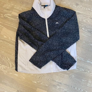 Mörkblå och vit jacka från J.Lindeberg - Snygg svartvit jacka från J.Lindeberg med ett prickigt mönster. Köpt för 2800 kr. Har inte kommit till andvändning och har därför inga defekter. Perfekt för sommarn om man kör golf elr bara nt vill bli mygg biten. Väldigt luftig❤️❤️❤️