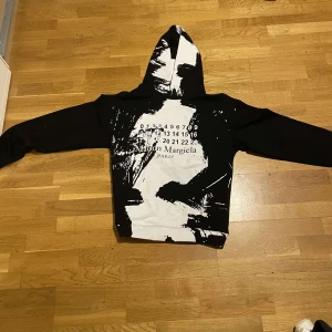 Svart och vit hoodie från Maison Margiela - Säljer min maison margiela hoodie, den var lite stor för mig och jag kan inte ha den på mig så nu säljer jag den, den är helt ny och precis fick den på min födelsedag kan alltid diskutera priset. Det är storlek 10 i fransk storlek och det är ungefär storlek M är europeisk storlek