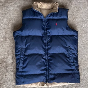 Ralph lauren  - En fet 2 i 1 Polo Ralph lauren väst som ej har andvänds mycket storlek Small ☀️. Västen går att andvända som mörkblå med röt Ralph lauren märke och Beige med mörkblå Ralph lauren märke.Sista bilden visar ett jätte lite håll något man aldrig skulle lägga märka till om man inte verkligen kollar.Pris går att diskutera.
