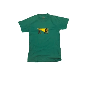 Grön t-shirt med tryck - Snygg grön t-shirt med ett unikt tryck på framsidan.                                                                    Storlek:S Längd:62cm Midjeöppning:45cm Ermöppning:16cm 