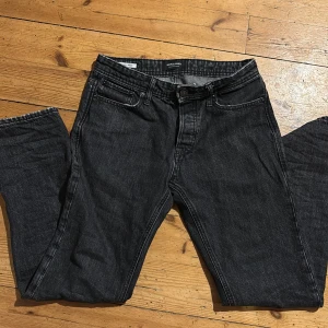 Svarta jeans från Jack & Jones - Snygga svarta jeans från Jack & Jones med klassisk femficksdesign. Storlek w28L32