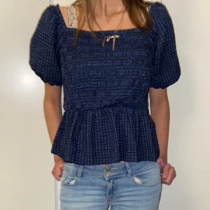 Blå rutig blus - Säljer en söt blå rutig blus med puffiga kortärmar och en volangdetalj i nederkant. Pris kan diskuteras!💘
