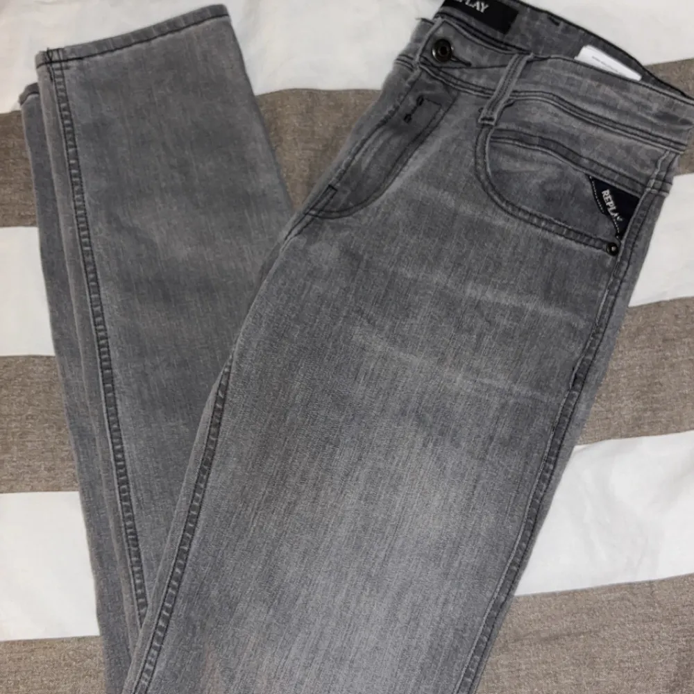 Snygga grå jeans från Replay med klassisk femficksdesign och knappgylf. De har en stilren look med diskreta sömmar och en bekväm passform. Perfekta för en avslappnad stil. PRIS GÅR ATT DISKUTERA. Farkut & Housut.