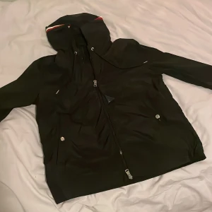 Moncler windbraker - Tjena, jag säljer nu denna eftertraktade windbrakern ifrån moncler! Den är i mycket gott skick och i en snygg svart färg med moncler märket på vänstra armen. Den är använd bara ett par gånger och väldigt varsamt. Ny pris på dessa ligger på runt 9000, mitt pris är endast 2999! Hör av er vid frågor eller funderingar😊