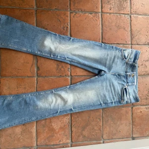 Blå jeans med bootcut - Snygga blå jeans med bootcut-stil och låg midja. De har en klassisk femficksdesign. Andvänt ungefär 4 gånger. Midjemått: 34-35 men väldigt stretchiga Innerbenslängd: 65
