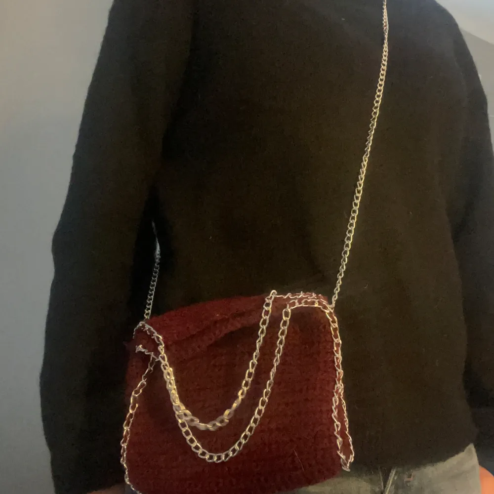 Snygg röd virkad väska med en cool kedja som axelrem. Perfekt för att ge din outfit en unik touch. Man kan även köpa andra färger på kedja och själva väskan. Skriv om ni har frågor och svara gärna tillbaka när jag svarat er💕. Laukut & Käsilaukut.