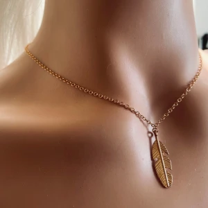 Made by prisförslag- Guldhalsband med fjäderhänge - Elegant guldhalsband med ett stilrent fjäderhänge. Perfekt för att ge en bohemisk touch till din outfit. Kedjan är tunn och smidig, vilket gör den bekväm att bära hela dagen.