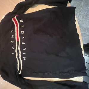 Svart tröja från Tommy Hilfiger - Svart Tommy hilfiger tröja utan luva, veldigt skön inuti och stretcig.
