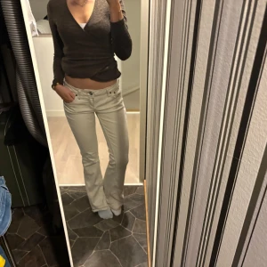 Beige bootcut jeans - Snygga beige bootcut jeans med hög midja. Perfekta för en avslappnad stil. De har en klassisk design med knappar och dragkedja framtill. Märket är BDG, men w27, är 165 lång o de passar perfekt.