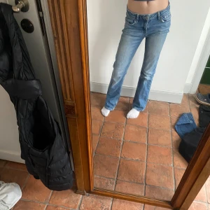 Blå jeans med slitna detaljer - Snygga lowwaist  bootcut jeans, några defekter längst ner! Midjemått:34 Innerbenslängd:71