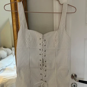 Vit randig korsettopp - Snygg vit korsettopp med svarta ränder och snörning framtill. Toppen är endast använd en gång. Axelbanden var för stora för mig, så ja sydde in dem där bak, men det är ingenting som syns. ❤️