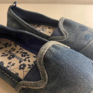 Blå loafers från Atmosphere - Snygga blå loafers i denim från Atmosphere. Skorna har en enkel design med rundad tå och dekorativa sömmar. 