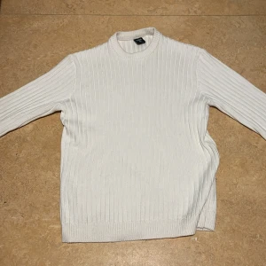 Vit ribbad tröja - Säljer en stilren vit ribbad tröja med långa ärmar. Perfekt för en enkel och klassisk look. Tröjan har en rund halsringning och är gjord i ett mjukt material.