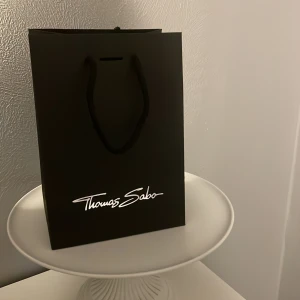 Svart presentpåse från Thomas Sabo - Säljer en elegant svart presentpåse från Thomas Sabo med vit logoty som är helt ny.