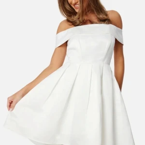 Vit axelbandslös klänning från Bubbleroom - Säljer en elegant vit axelbandslös klänning från Bubbleroom. Klänningen har en vacker, utsvängd kjol och en stilren design som passar perfekt för speciella tillfällen. Den har en dragkedja i sidan för enkel påklädning. 🎓