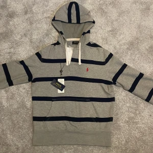 Ralph Lauren hoodie - Tja. Säljer denna sjukt unika Polo Ralph Lauren hoodie. Den är väldigt skön och passar perfekt nu till vintern/våren. Skicket är perfekt förutom ett litet hål vid fickan men det är inget som märks av. Nypris runt 2000. Mitt pris 699kr