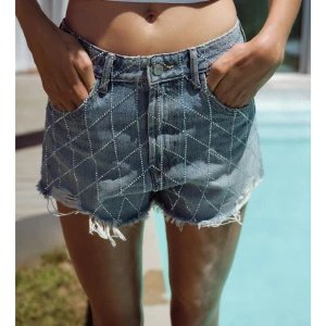 Blå jeansshorts med bling - Snygga blå jeansshorts med diamantmönster och fransiga kanter. Perfekta för en avslappnad sommarlook vid poolen eller stranden. Nya med prislapp💗nypris 400kr