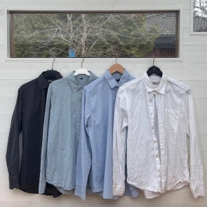Fyra långärmade skjortor i olika färger - Säljer fyra stilrena långärmade skjortor i svart, ljusblått, blått och vitt. Perfekta för både vardag och mer formella tillfällen. Skjortorna är från lydande: dressmann , Tiger of sweden, uptown och Muji. Alla i storlek S förutom den andra från höger som är storlek L.