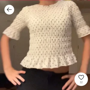 Svart prickig blus - Säljer en söt svart blus med vita prickar. Blusen har trekvartsärmar och en smockad design som ger en fin passform. Den har också en volangdetalj vid nederkanten. Första bilden är lika dan tröja i vit🥰