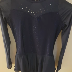 Marinblå konståkningsklänig - Säljer min konståkningskläning. Köpte på Decathlon för ganska länge sen man har typ använt fem gånger. Storlek 14 år typ xs. Jättebra kvalitet. Inge diamant har ramlat av. 