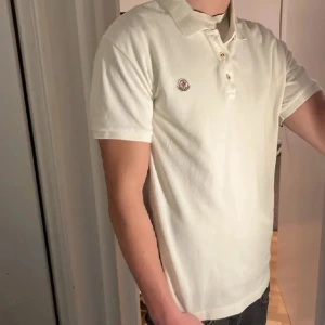 Moncler piké (ÄKTA) - Tja säljer en Moncler piké i färgen piké och i storlek XL men sitter mer som M/L . Nypris 3599 KR mitt pris 699 KR. Inga defekter som hål eller fläckar. Skriv vid frågor eller funderingar, om du är osäker på storlek kan jag skicka mått och även mer äkthetsbevis!