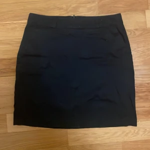 Mörkblå kjol - Snygg mörkblåkjol kjol. Kjolen har en diskret dragkedja baktill och är perfekt för en stilren look. Den är i storlek S. 