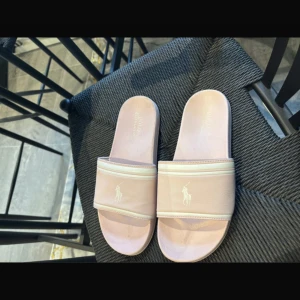Rosa sandaler från Polo Ralph Lauren - Snygga rosa sandaler från Polo Ralph Lauren med en stilren design och logotyp på remmen. Använda en gång.
